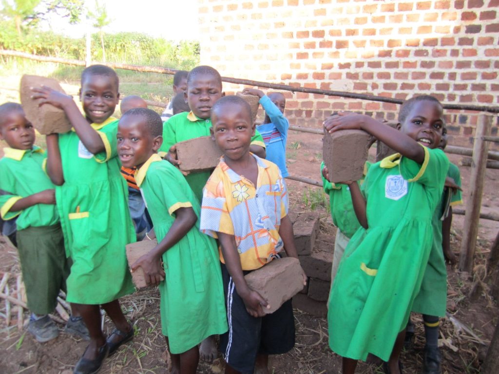 Schulkinder tragen Ziegel