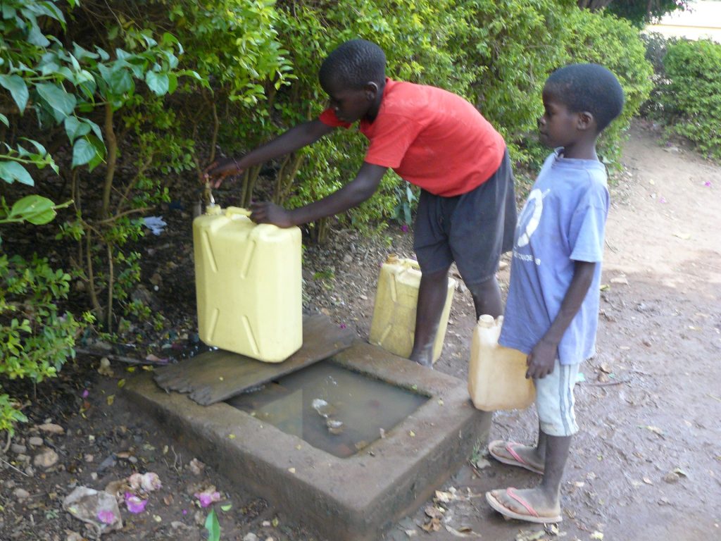Kinder füllen Wasserkanister